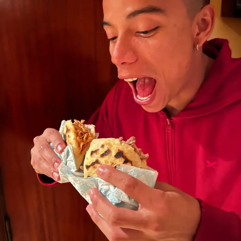 Retail 2 Chico colombiano comiendo dos arepas en España, Tarragona, una de carne y otra de pollo.