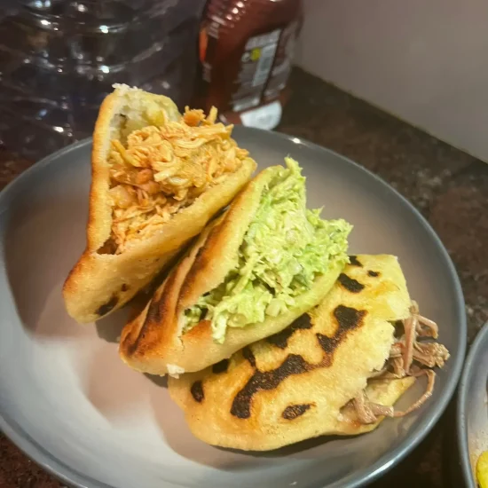 Una plato con 3 arepas. Una Arepa con relleno distontos como Reina Pepiada, de Pollo o Carne Mechada.